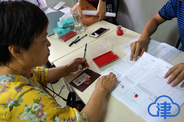 (张贵荣在选房确认书上签字,按下手印)